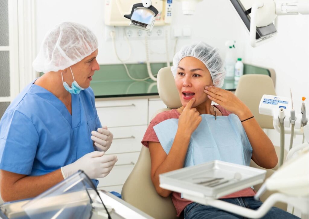 Patient discussing dental abscess self care and jaw discomfort with a dentist during an emergency dental consultation