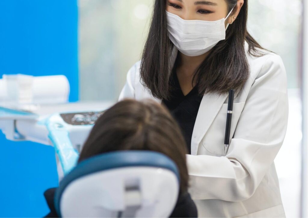 Dentist examining a patient's mouth for signs of an infected tooth during a comprehensive dental evaluation.