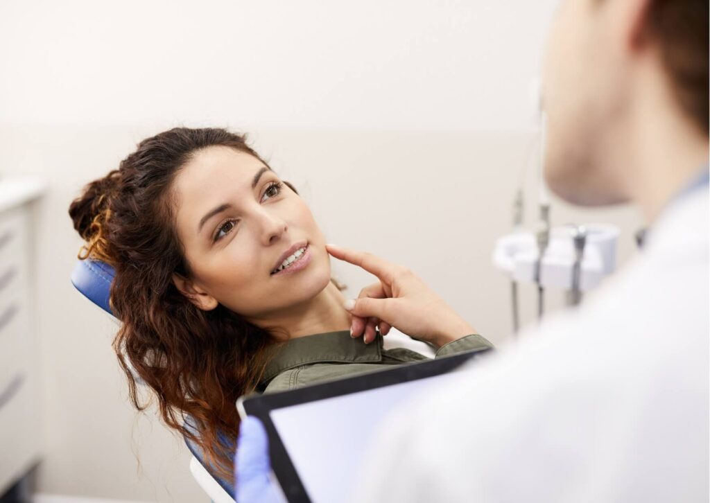 Patient discussing sore gums with a dentist during an exam for gingivitis evaluation and treatment planning.