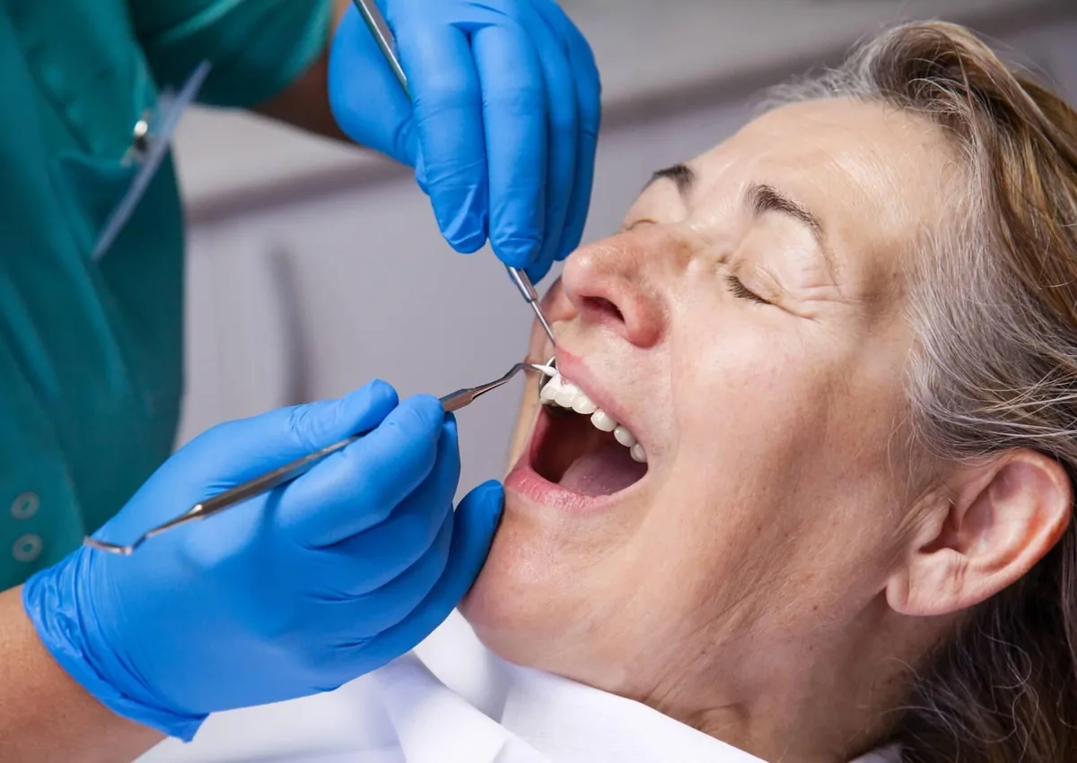 Dental professional examining a patient’s gums for signs of gingival hyperplasia.