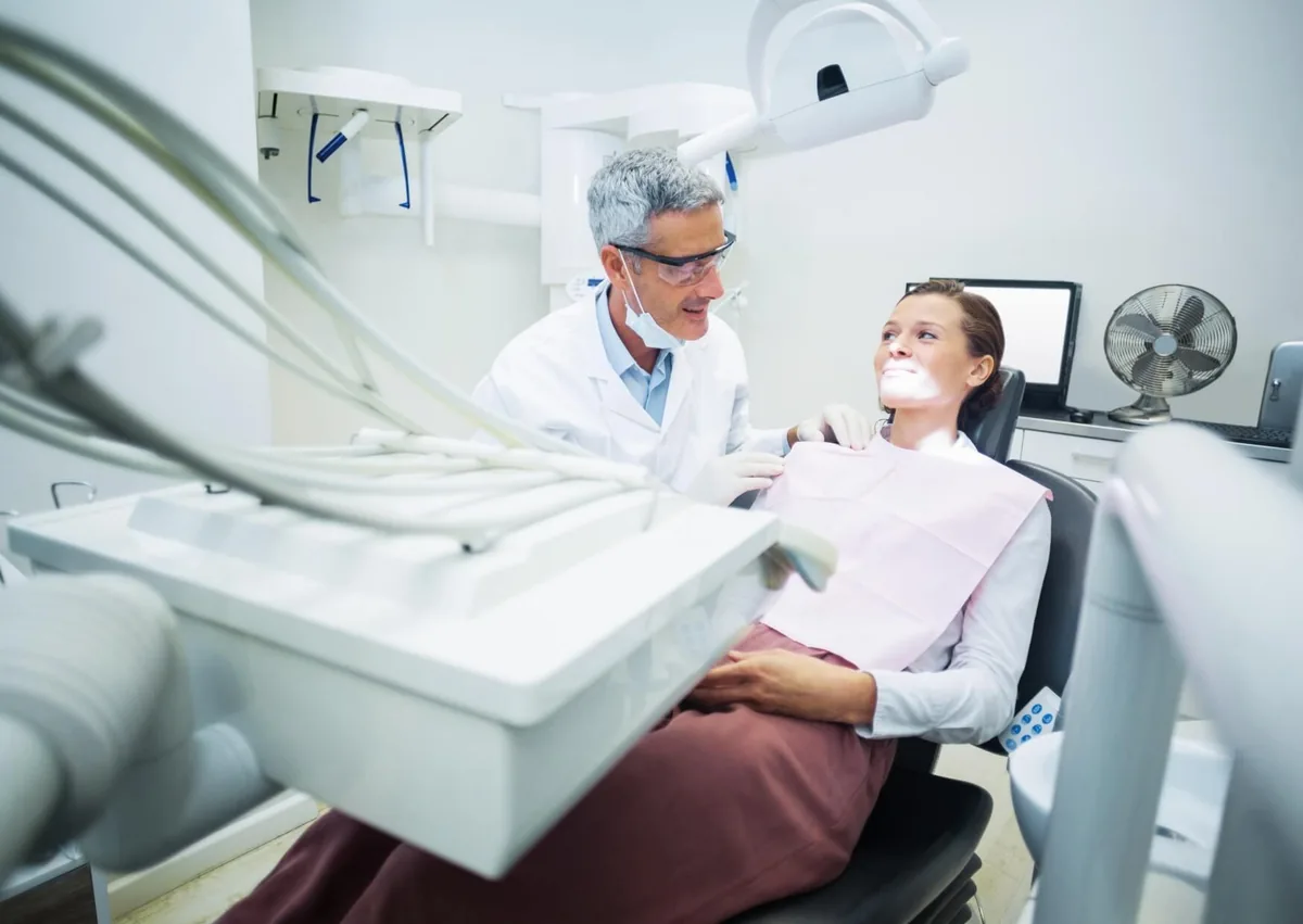 Patient discussing when to resume normal foods after wisdom teeth removal with a dentist.