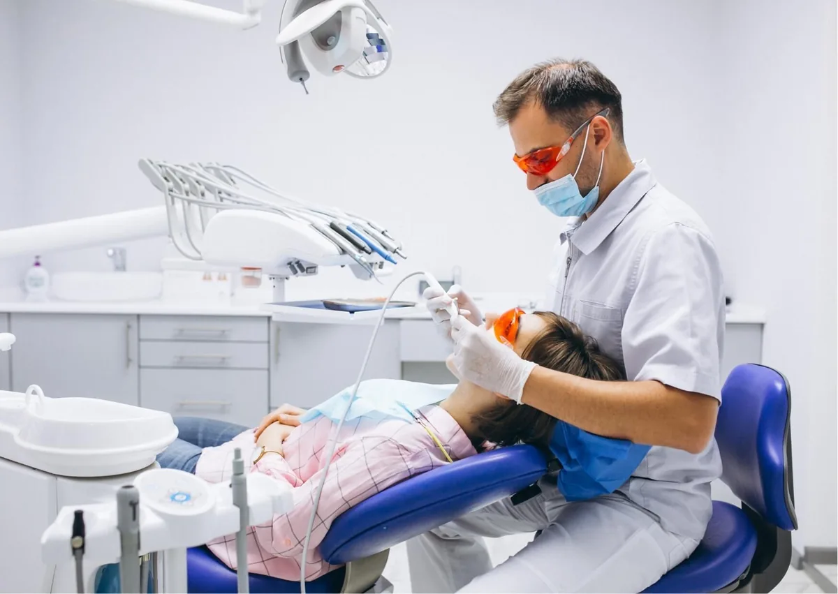 Dentist performing a dental procedure while a patient receives sedation dentistry for added comfort.