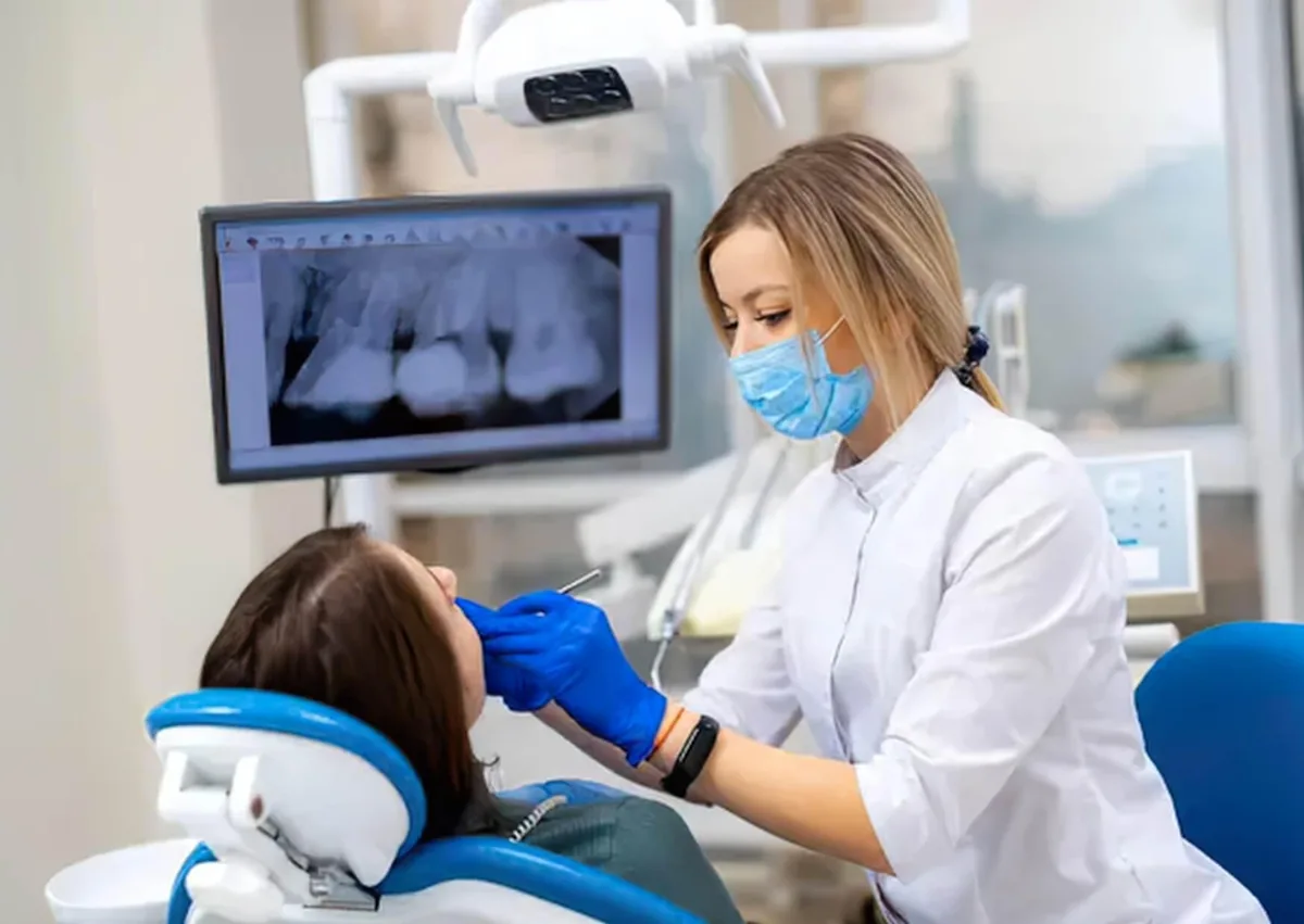Dentist examining a patient and reviewing X-rays during an affordable dental implant consultation.