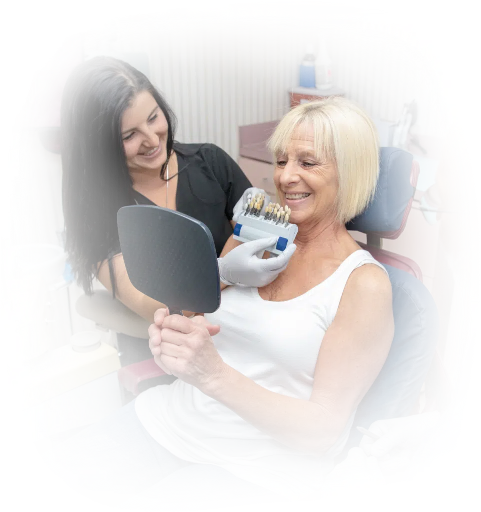 lady smiling in mirror with dentist
